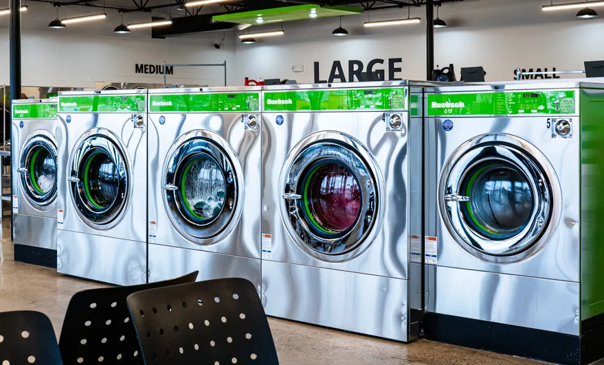 Row of Huebsch front-load washers in a self-service laundromat